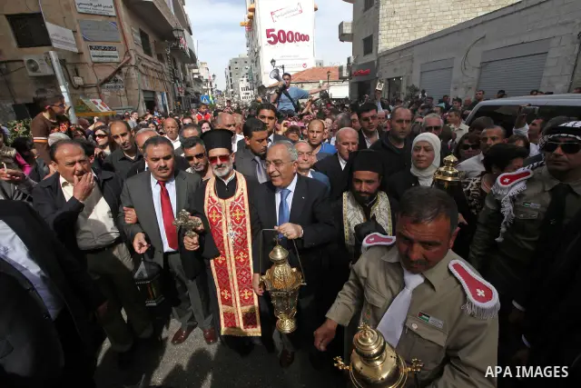 Palestinian Prime Minister Salam Fayyad takes part in the "Holy Fire" procession on the eve of Orthodox Easter in the West Bank city of Ramallah on April 14, 2012. The date of Orthodox Easter is calculated differently th...