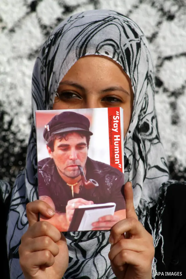 A Palestinian artist puts the final touches on a black and white mural painting dedicated to late Italian activist Vittorio Arrigoni in Gaza City on April 14, 2012, as Gazans marked the first anniversary of his murder in...