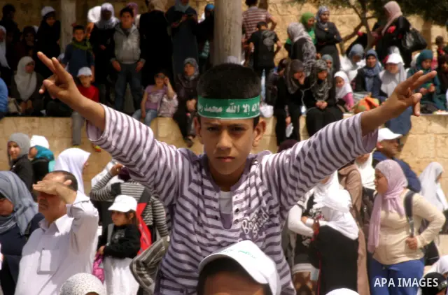 Palestinians gathers in front of Jerusalem's Dome of the Rock mosque inside the courtyard of the Al-Aqsa mosques compound, Islam's third holiest site, during a ceremony marking the international Children's Day on April 1...