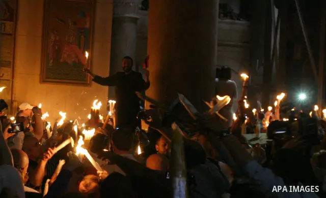 Christian Orthodox worshipers hold up candles lit from the 'Holy Fire' as thousands gather in the Church of the Holy Sepulchre in Jerusalem's old city on April 14, 2012 during the 'Holy Fire' ceremony on the eve of the O...