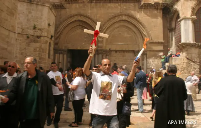 Palestinian Christians from the Greek Orthodox Church chant and sing in the streets with candles and crosses during the Easter Holy Fire ritual in the Old City of Jerusalem on April 14, 2012. during the 'Holy Fire' cerem...