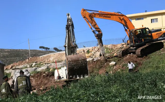 Israeli border police officers stand guard as demolition vehicles destroy a man-made reservoir on a Palestinian farm near the West Bank city of Hebron, on Apr. 16, 2012. Reports state that tensions rose as Palestinian ho...
