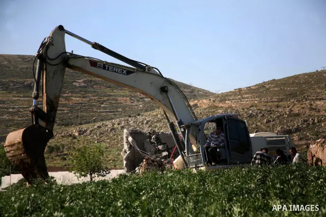 Israeli border police officers stand guard as demolition vehicles destroy a man-made reservoir on a Palestinian farm near the West Bank city of Hebron, on Apr. 16, 2012. Reports state that tensions rose as Palestinian ho...
