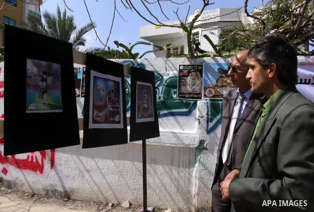 Palestinians look at the murals during a protest during a protest calling for the release of Palestinian prisoners held in Israeli jails inside the grounds of the Red Cross office in Gaza City on April 16, 2012. Some 1,6...