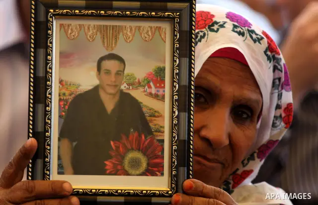 Palestinian women hold up portrait of incarcerated relatives during a protest calling for the release of Palestinian prisoners held in Israeli jails inside the grounds of the Red Cross office in Gaza City on April 16, 20...