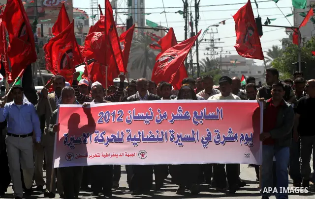 Palestinian protesters wave national flags during a rally in Gaza City on April 17, 2012 in solidarity with Palestinian prisoners held in Israel. Some 1,200 Palestinian prisoners held in Israeli jails have begun a hunger...