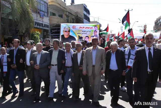 Palestinian protesters wave national flags during a rally in Gaza City on April 17, 2012 in solidarity with Palestinian prisoners held in Israel. Some 1,200 Palestinian prisoners held in Israeli jails have begun a hunger...