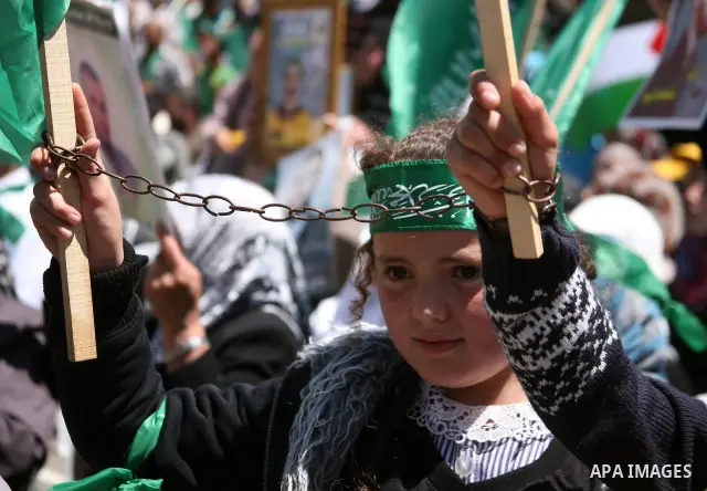 Palestinian protesters wave national flags during a rally in West Bank city of Hebron on April 17, 2012 in solidarity with Palestinian prisoners held in Israel. Some 1,200 Palestinian prisoners held in Israeli jails have...