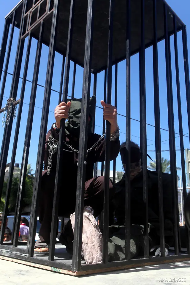 Palestinian boys with handcuffs attend a rally to commemorate the Palestinian Prisoner Day in Gaza City, on April 17, 2012. The Israeli Prisons Authority said on Tuesday in a written statement that 2,300 Palestinian pris...