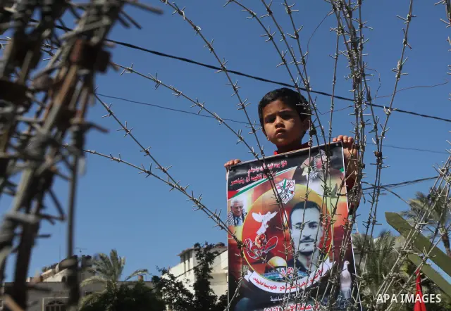 Palestinian boys with handcuffs attend a rally to commemorate the Palestinian Prisoner Day in Gaza City, on April 17, 2012. The Israeli Prisons Authority said on Tuesday in a written statement that 2,300 Palestinian pris...
