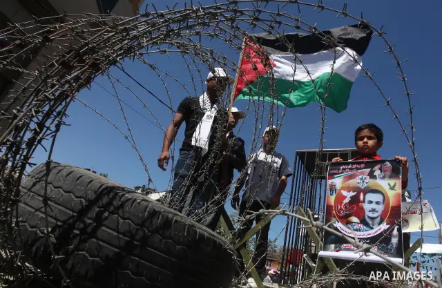 Palestinian boys with handcuffs attend a rally to commemorate the Palestinian Prisoner Day in Gaza City, on April 17, 2012. The Israeli Prisons Authority said on Tuesday in a written statement that 2,300 Palestinian pris...