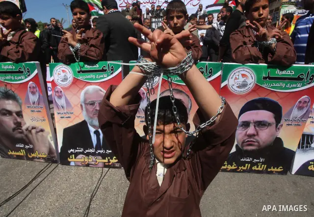 Palestinian boys with handcuffs attend a rally to commemorate the Palestinian Prisoner Day in Gaza City, on April 17, 2012. The Israeli Prisons Authority said on Tuesday in a written statement that 2,300 Palestinian pris...