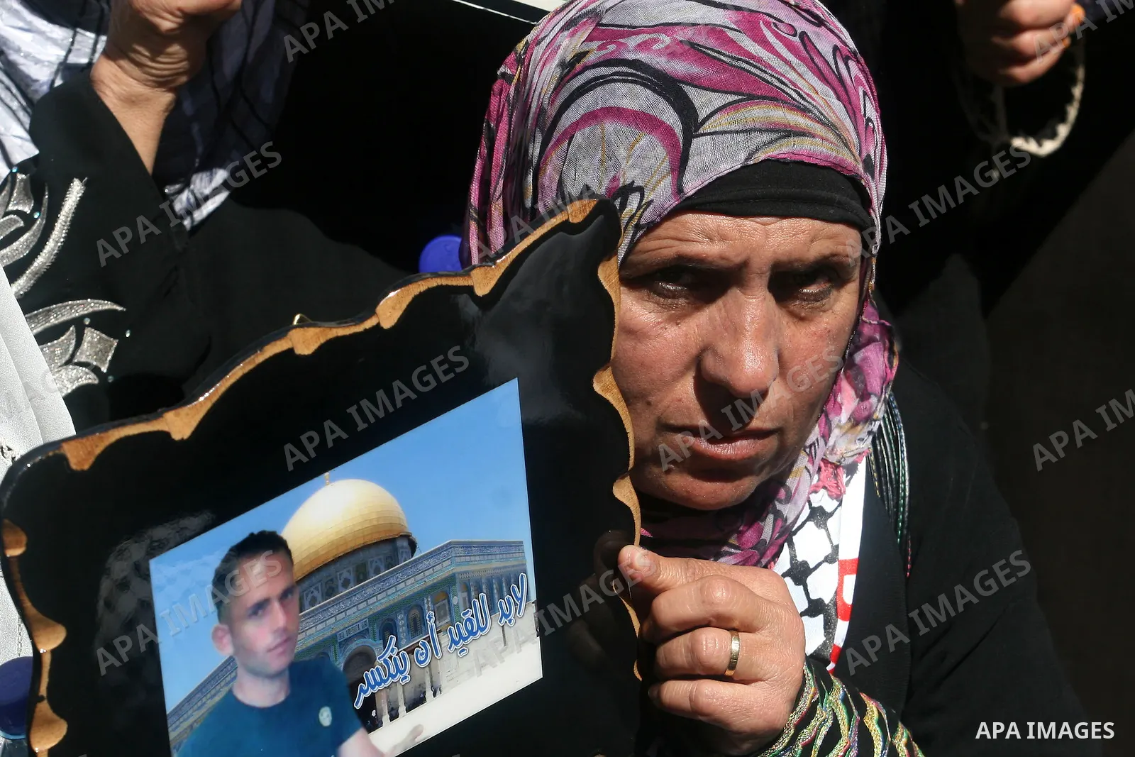 Palestinians hold a photograph of a prisoner jailed in Israel, during a rally marking the annual prisoners' day in the West Bank city of Ramallah, Tuesday, April 17, 2012. Hundreds of Palestinian prisoners held by Israel...