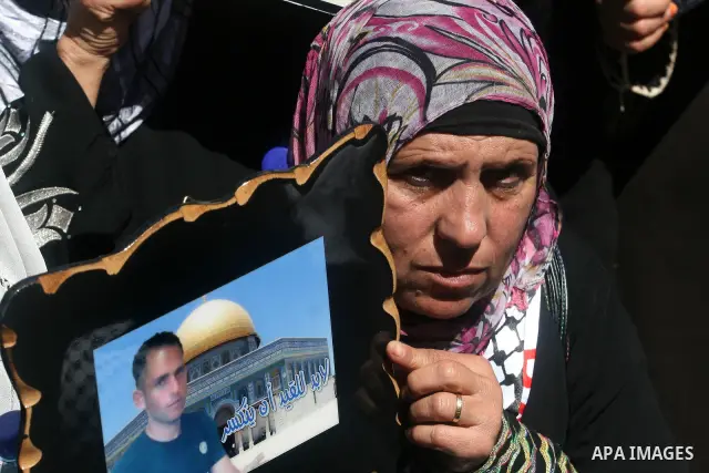 Palestinians hold a photograph of a prisoner jailed in Israel, during a rally marking the annual prisoners' day in the West Bank city of Ramallah, Tuesday, April 17, 2012. Hundreds of Palestinian prisoners held by Israel...