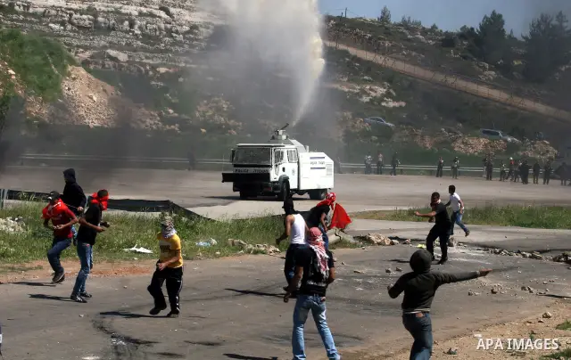 A Palestinian protester walks amid teargas fired by Israeli soldiers during a demonstration to mark the Prisoners' Day near Israels Ofer prison, between Jerusalem and Ramallah on April 17, 2012. At least 1,200 Palestini...