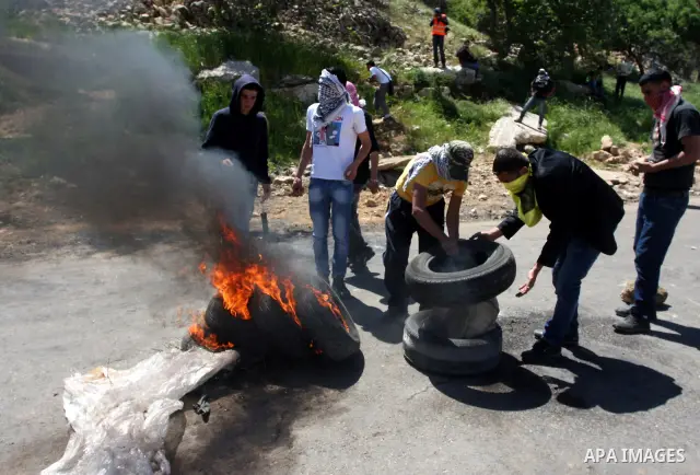 A Palestinian protester accidentally sets himself on fire while throwing a Molotov cocktail towards the Israeli soldiers during clashes following a demonstration to mark the Prisoners' Day near Israels Ofer prison, betw...