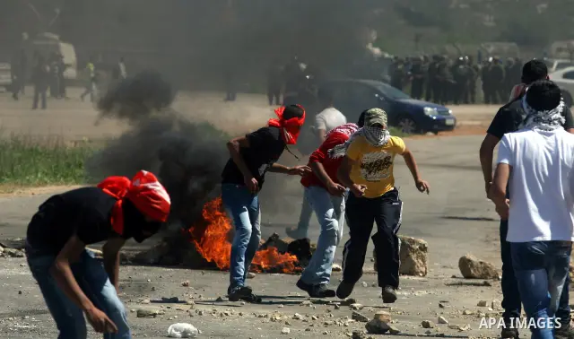A Palestinian protester accidentally sets himself on fire while throwing a Molotov cocktail towards the Israeli soldiers during clashes following a demonstration to mark the Prisoners' Day near Israels Ofer prison, betw...