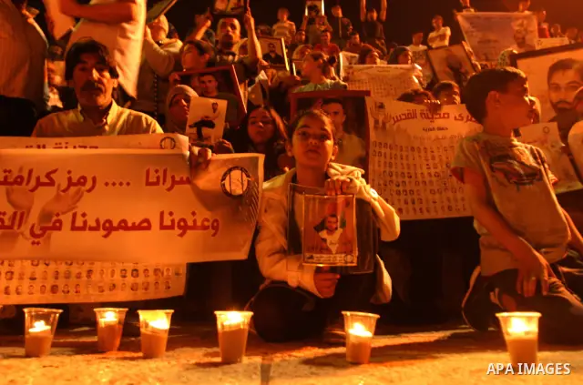 Palestinians hold portraits of relatives jailed in Israeli prisons as they protest to demand for their release during a demonstration to mark Prisoners' Day outside the Damascus gate, in the old city of Jerusalem on Apri...