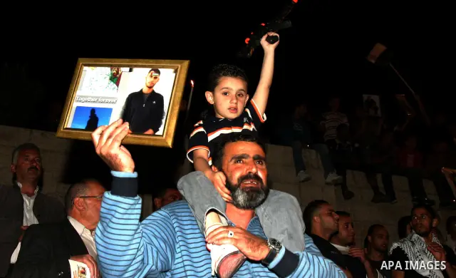 Palestinians hold portraits of relatives jailed in Israeli prisons as they protest to demand for their release during a demonstration to mark Prisoners' Day outside the Damascus gate, in the old city of Jerusalem on Apri...