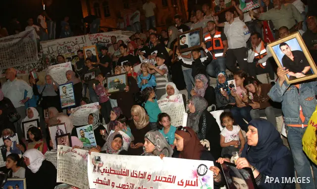 Palestinians hold portraits of relatives jailed in Israeli prisons as they protest to demand for their release during a demonstration to mark Prisoners' Day outside the Damascus gate, in the old city of Jerusalem on Apri...