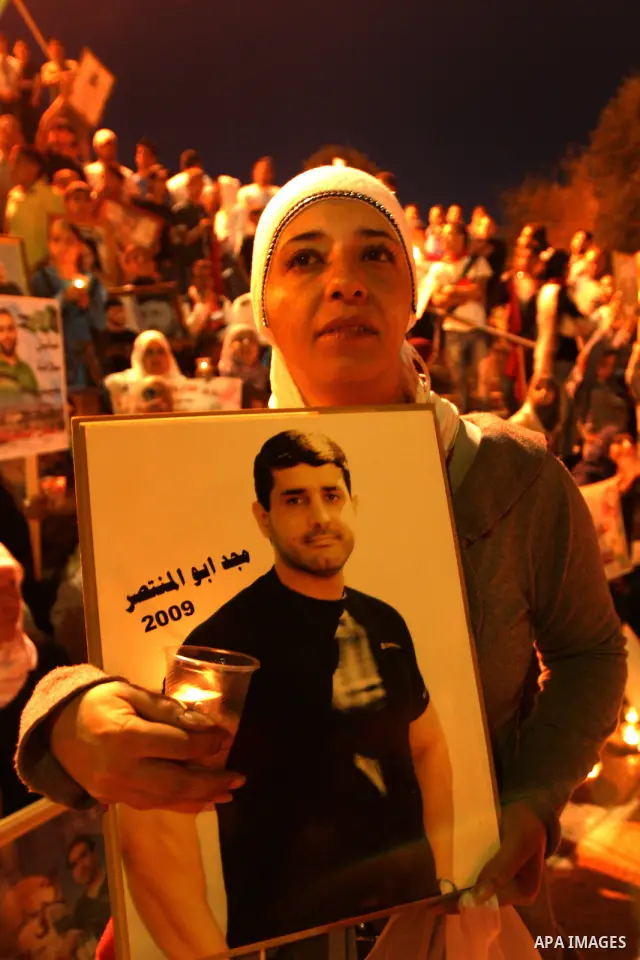 Palestinians hold portraits of relatives jailed in Israeli prisons as they protest to demand for their release during a demonstration to mark Prisoners' Day outside the Damascus gate, in the old city of Jerusalem on Apri...