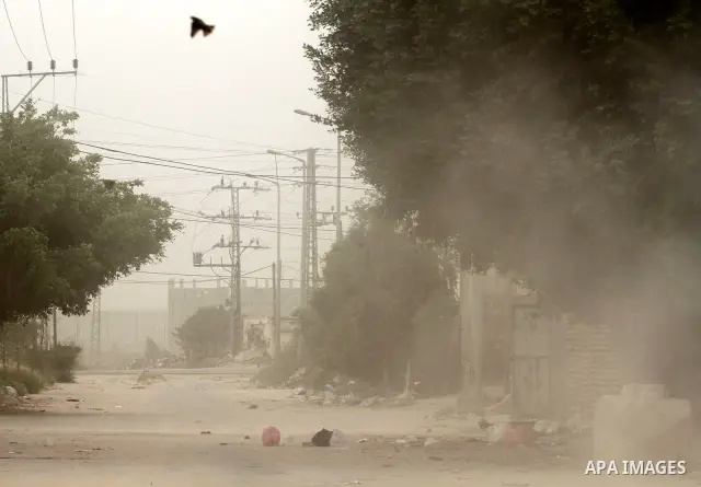 Palestinians walk on the street during hot winds and sand storms in Gaza City on April 18, 2012. Photo by Mohammed Asad