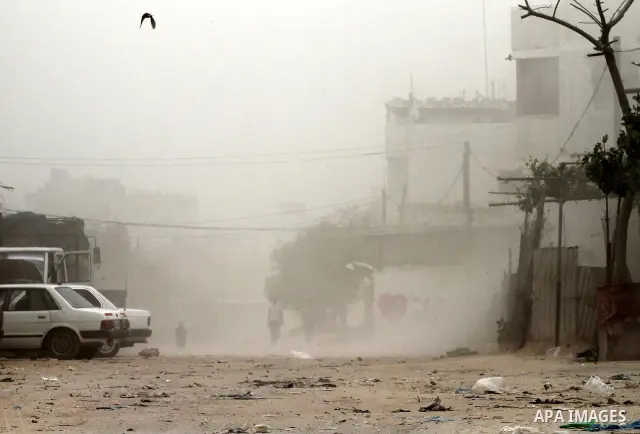 Palestinians walk on the street during hot winds and sand storms in Gaza City on April 18, 2012. Photo by Mohammed Asad
