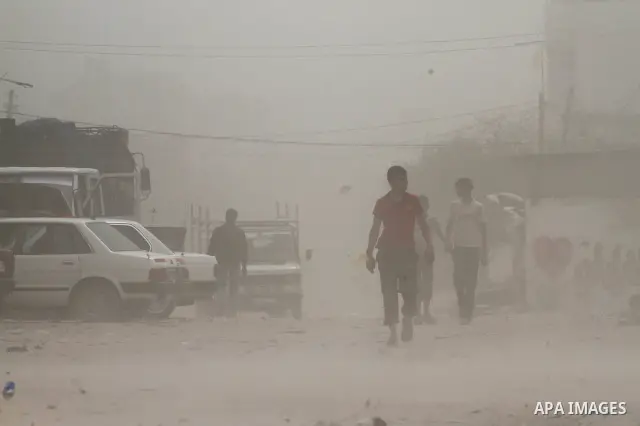 Palestinians walk on the street during hot winds and sand storms in Gaza City on April 18, 2012. Photo by Mohammed Asad