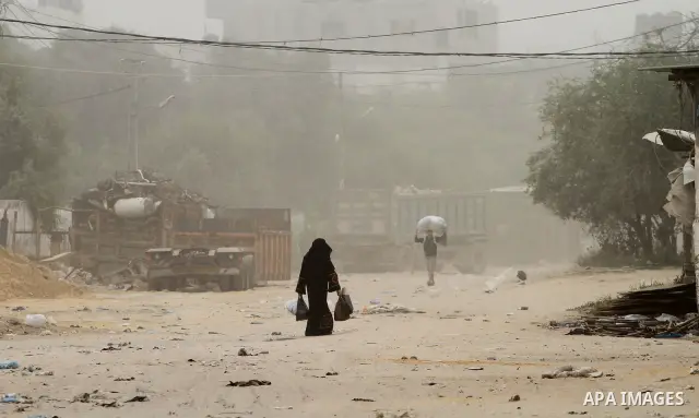 Palestinians walk on the street during hot winds and sand storms in Gaza City on April 18, 2012. Photo by Mohammed Asad