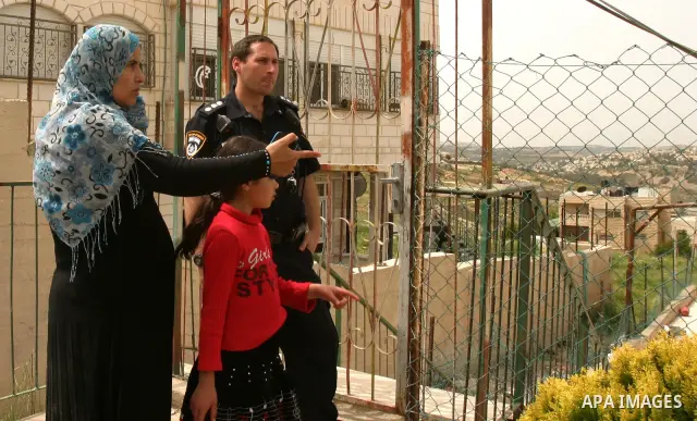 Israeli police stand guard as Palestinian members of the Khaled Natsheh household remove household items after being forced to hand over their home to Jewish settlers in the Israeli annexed east Jerusalem neighbourhood o...