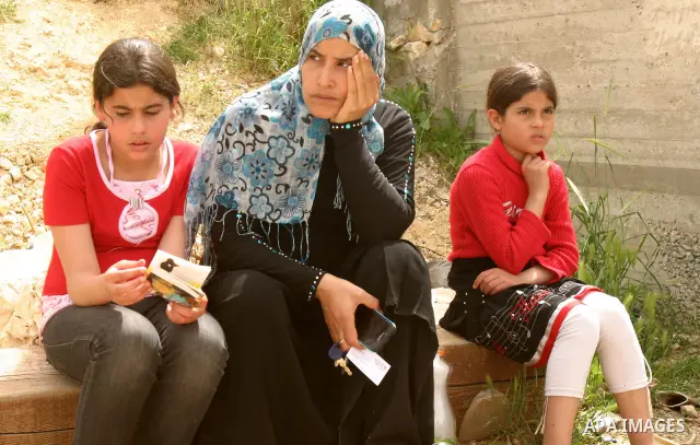 Female Palestinian members of the Khaled Natsheh household look on as their furniture is removed following their forced eviction by Israeli authorities, handing over their home to Jewish settlers in the Israeli annexed e...