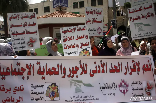 Palestinians hold banners and flags during a march calling for the imposition of the law of collateral social worker for the Palestinian, in April 19, 2012 in the West Bank city of Nablus. Photo by Wagdi Eshtayah.