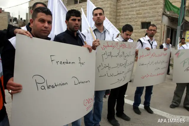 Staff of the Palestinian Red Crescent Society, wave flags and banners during a rally in solidarity with prisoners in Israeli jails, in the West Bank city of Ramallah, April 19, 2012. Photo by Issam Rimawi