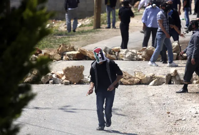 Palestinians protester readies to throw a stone at the Israeli military during a demonstration against the expropriation of Palestinian land by Israel in the village of Kafr Qaddum, near the northern city of Nablus in th...