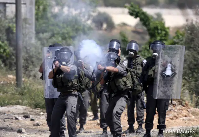 Israeli soldiers fire teargas canisters against Palestinian protesters as they demonstrate against the expropriation of Palestinian land by Israel in the village of Kafr Qaddum, near the northern city of Nablus in the oc...