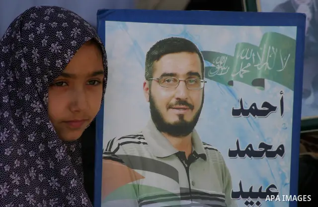Palestinians hold pictures of a relatives currently being held in an Israeli jail, during a rally outside of the International Red Cross building in east Jerusalem, on April 20, 2012. Photo by Mahfouz Abu Turk