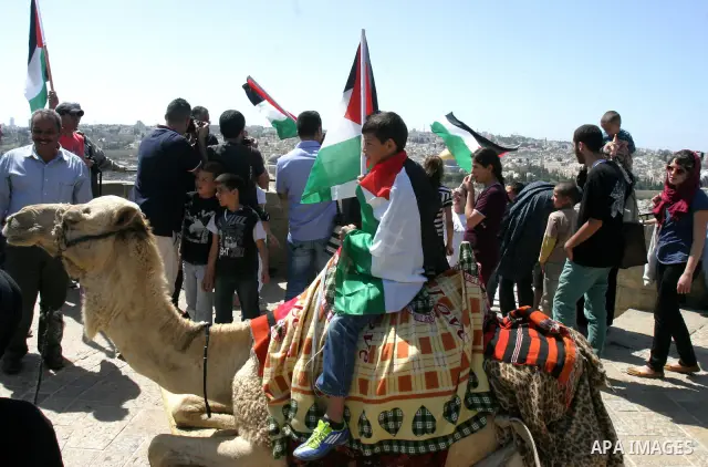 Palestinian demonstrate on the Mount of Olives, which overlooks the Dome of the Rock in the Al-Aqsa mosque compound, as they protest against the Jewish settlers who live in the Israeli annexed Arab East Jerusalem's a-Tur...