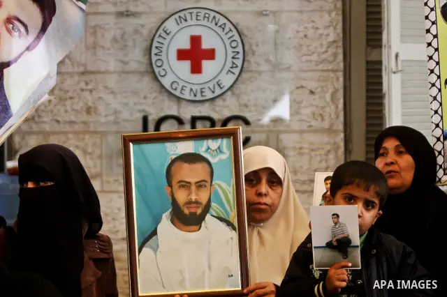 A Palestinian woman holding up a portrait of a jailed loved one takes part in a protest outside the Red Cross offices in Gaza City on April 23, 2012. Photo by Ali Jadallah