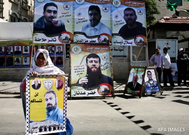 A Palestinian woman holding up a portrait of a jailed loved one takes part in a protest outside the Red Cross offices in Gaza City on April 23, 2012. Photo by Ali Jadallah