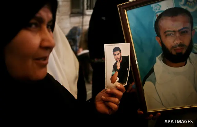 A Palestinian woman holding up a portrait of a jailed loved one takes part in a protest outside the Red Cross offices in Gaza City on April 23, 2012. Photo by Ali Jadallah
