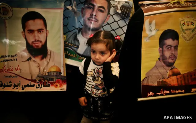 A Palestinian girl holding up a portrait of a jailed loved one takes part in a protest outside the Red Cross offices in Gaza City on April 23, 2012. Photo by Ali Jadallah