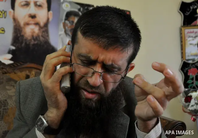 Former Palestinian hunger strike prisoner Khader Adnan, a senior member of Islamic Jihad who was jailed in Israel, uses his mobile at his house in the village of Arraba near the northern city of Jenin, in the Israeli occ...