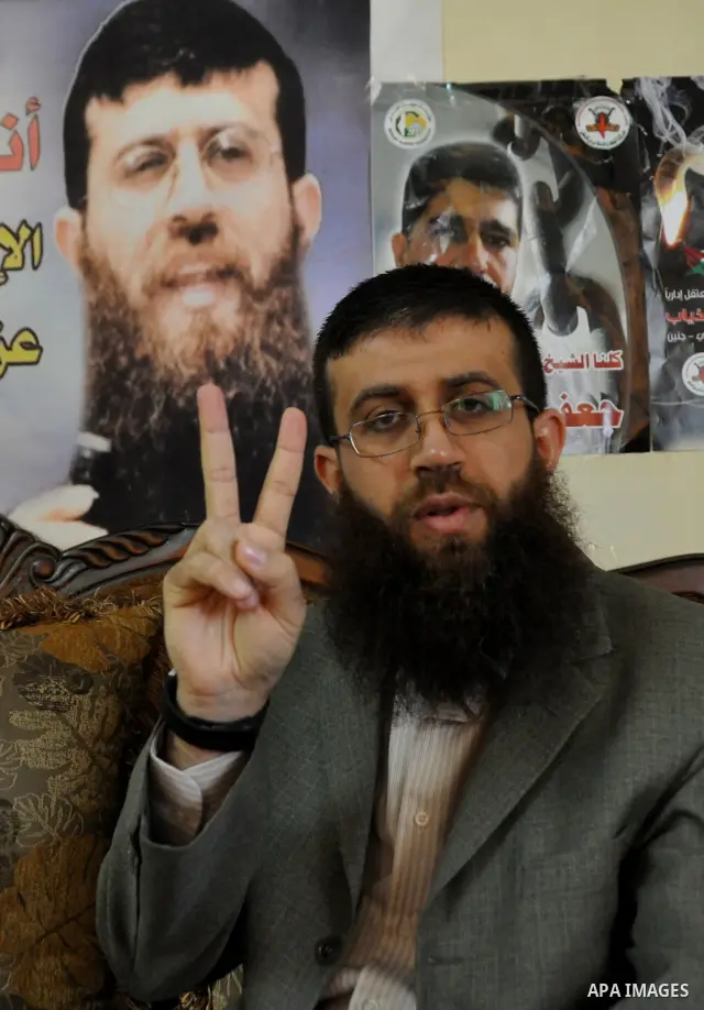 Former Palestinian hunger strike prisoner Khader Adnan, a senior member of Islamic Jihad who was jailed in Israel, shows the victory sign at his house in the village of Arraba near the northern city of Jenin, in the Isra...