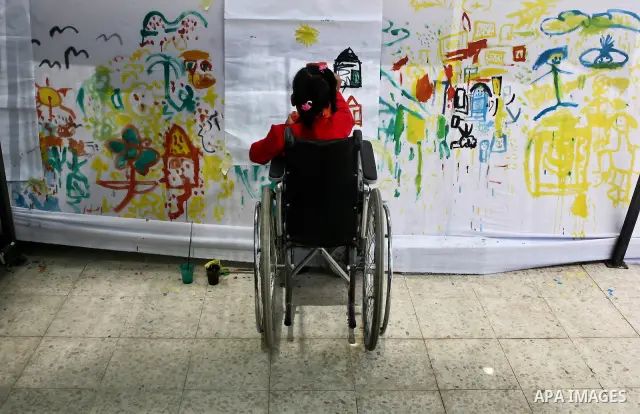 Palestinian disabled children draw and paint pictures at a charity association during a celebration in Gaza city on April 23,2012. Photo by Ali Jadallah