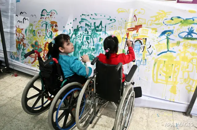 Palestinian disabled children draw and paint pictures at a charity association during a celebration in Gaza city on April 23,2012. Photo by Ali Jadallah