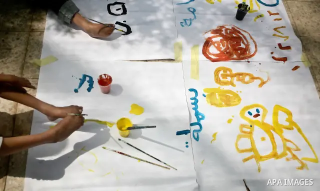 Palestinian disabled children use their feet to draw and paint pictures at a charity association during a celebration in Gaza city on April 23,2012. Photo by Ali Jadallah