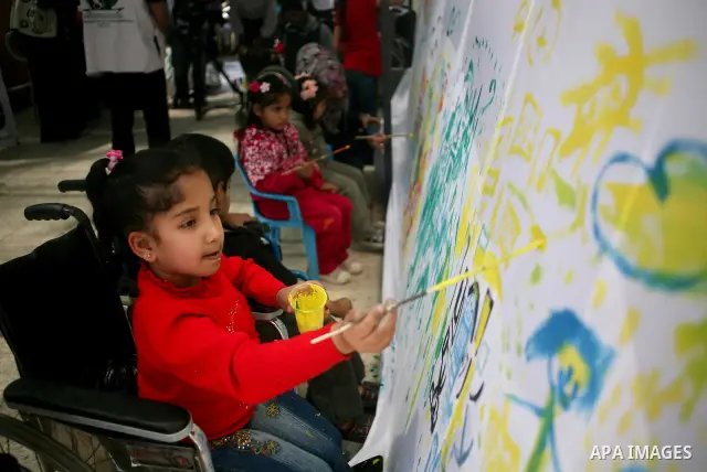 Palestinian disabled children draw and paint pictures at a charity association during a celebration in Gaza city on April 23,2012. Photo by Ali Jadallah