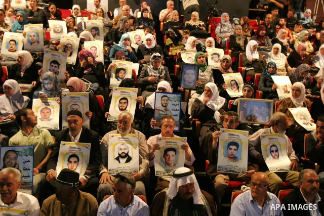 Palestinians hold portraits of relatives jailed in Israeli prisons as they protest to demand for their release,in the old city of Jerusalem on April 23, 2012. Photo by Mahfouz Abu Turk