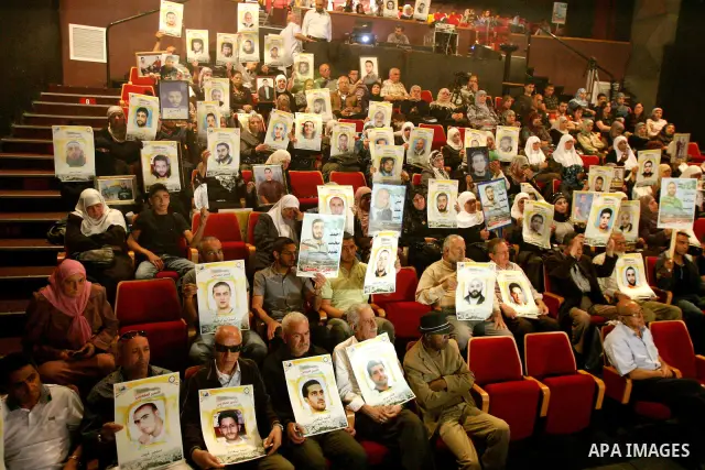 Palestinians hold portraits of relatives jailed in Israeli prisons as they protest to demand for their release,in the old city of Jerusalem on April 23, 2012. Photo by Mahfouz Abu Turk