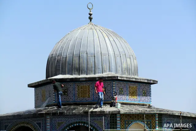 Palestinians workers clean up the dome of Al-Aqsa mosque in the old city of Jerusalem after fixing it on April 23, 2012. Photo by Mahfouz Abu Turk